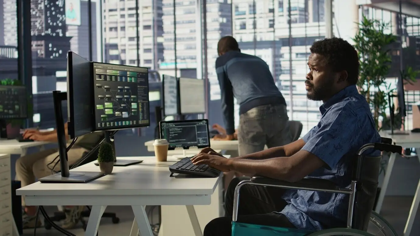 Техник по программному обеспечению с инвалидностью работает в инклюзивной рабочей среде.